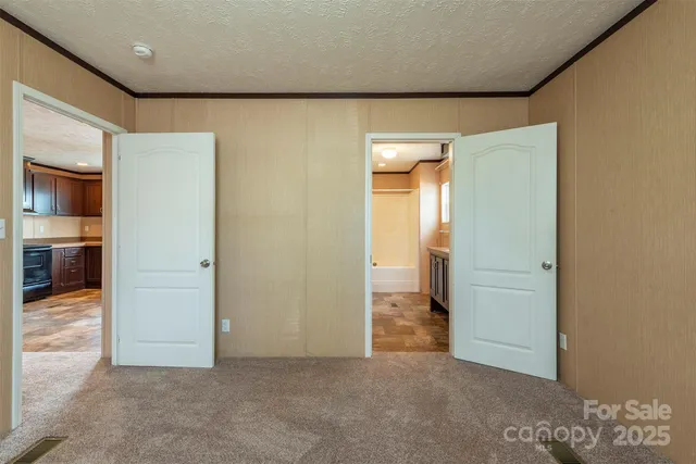 an empty room with closet and mirrors