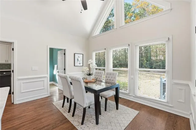 a kitchen with granite countertop white cabinets stainless steel appliances with dining table and chairs