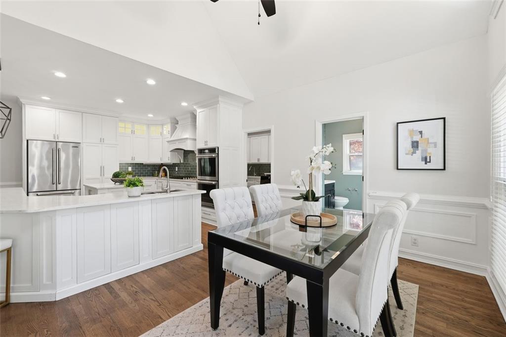 1520 Natchez Way Grayson, GA 30017 - Photo 14 of 63 a kitchen with granite countertop white cabinets stainless steel appliances with dining table and chairs