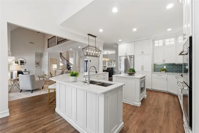 a kitchen with white cabinets stainless steel appliances and kitchen island