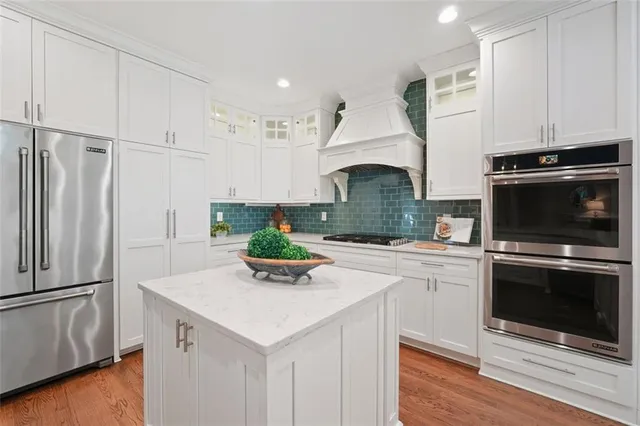 a kitchen with white cabinets and sink
