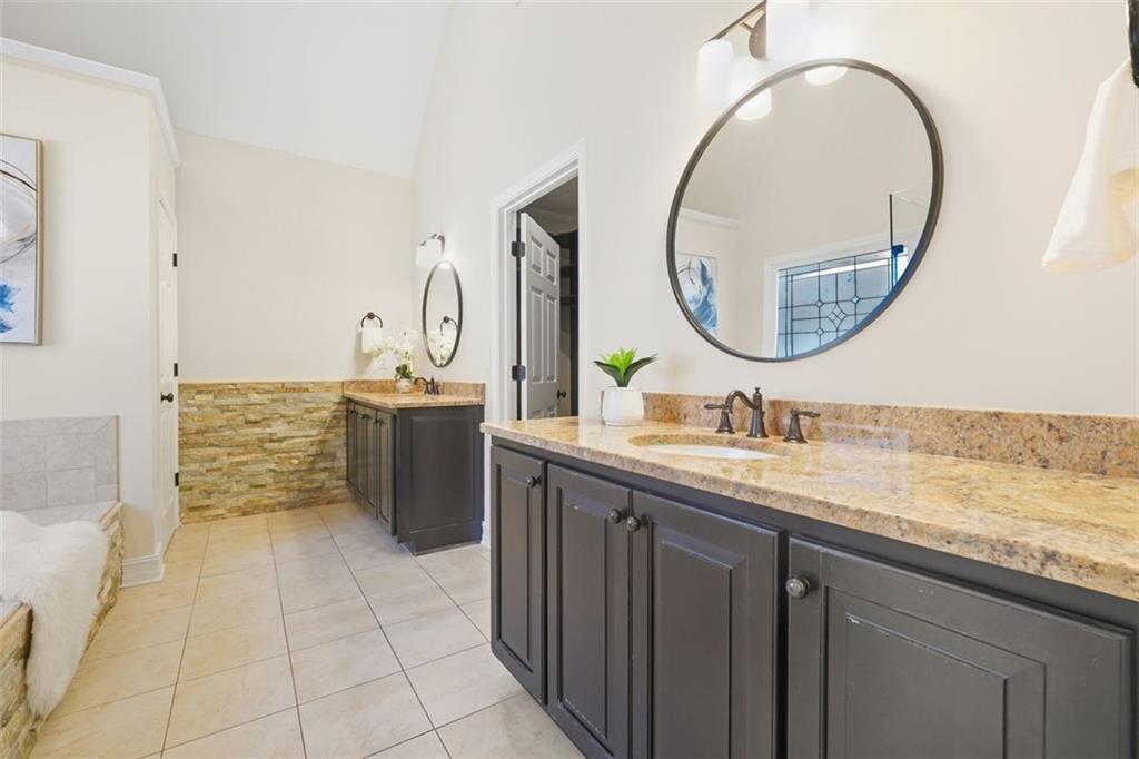 1520 Natchez Way Grayson, GA 30017 - Photo 29 of 63 a bathroom with a granite countertop sink a mirror and a