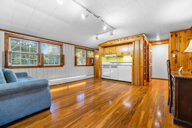 a living room with a couch and dresser with wooden floor