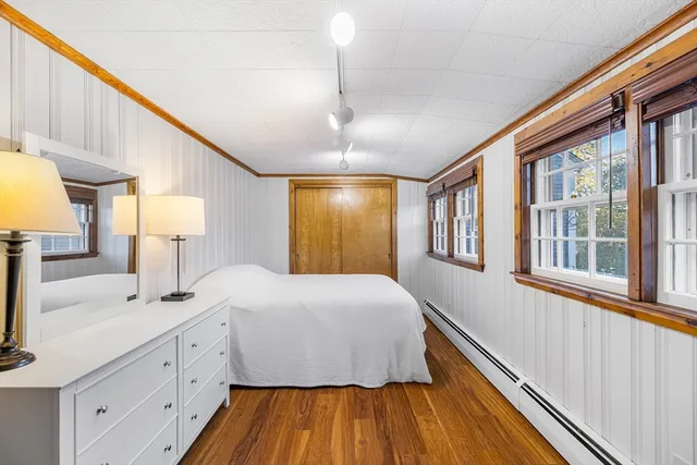 a spacious bedroom with a bed and wooden floor