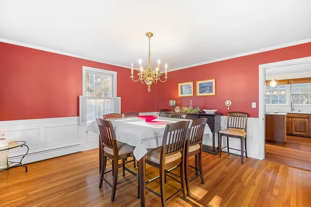 a dining room with furniture a chandelier and wooden floor