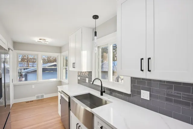 a kitchen with granite countertop a sink stove and cabinets