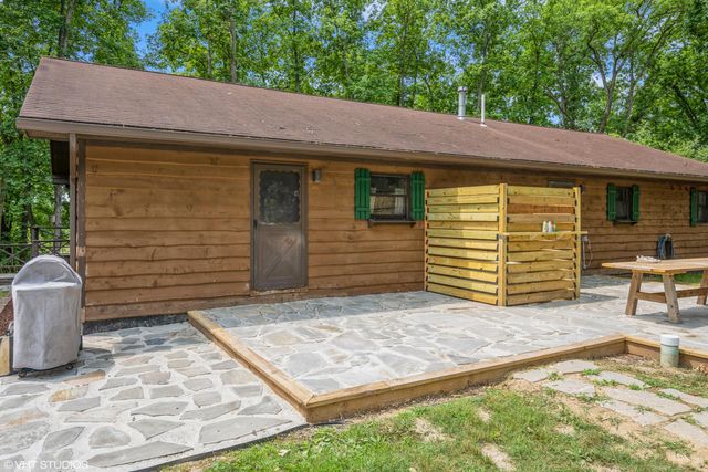 a view of a house with a small yard and wooden fence