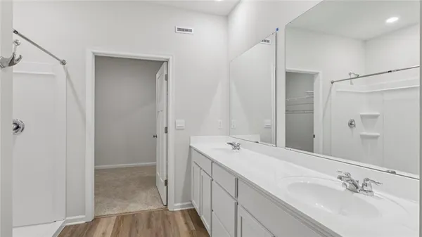 a view of bathroom with a sink mirror and shower