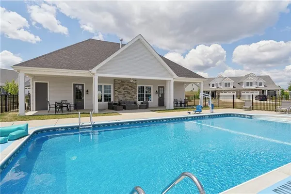 a view of a house with pool and a yard