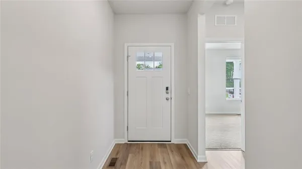 a view of a hallway with wooden floor and closet