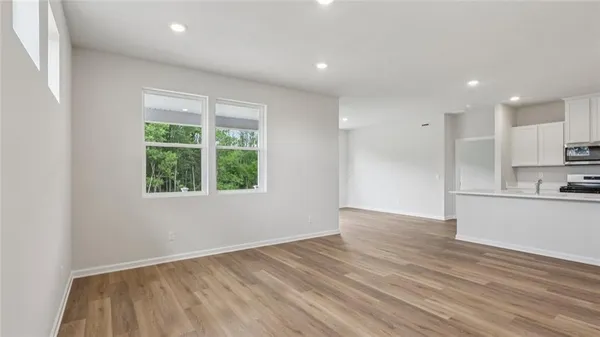 a view of a kitchen with wooden floor and a window