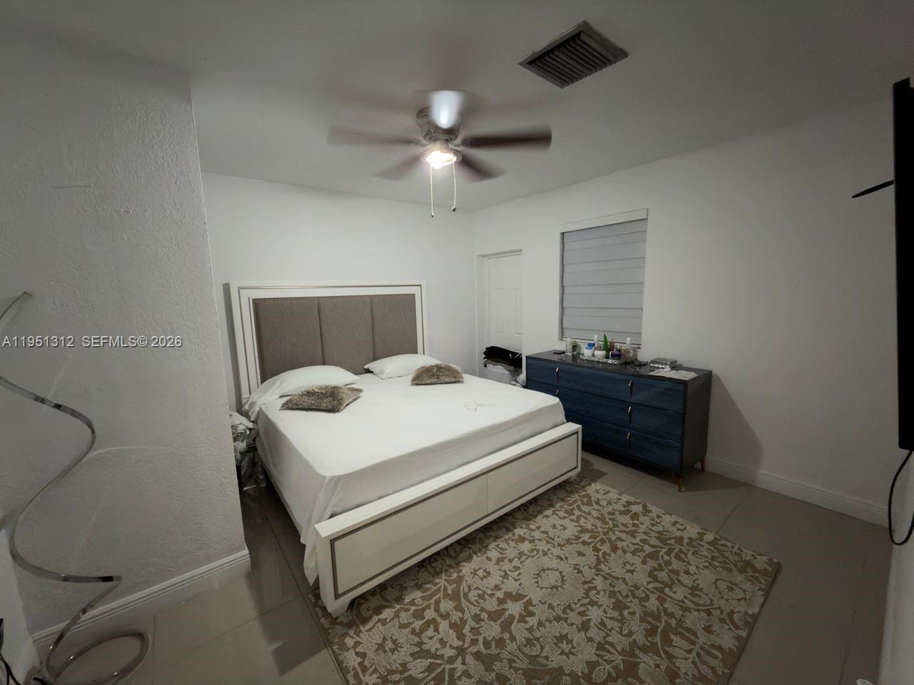 224 East 42nd Street Hialeah, FL 33013 - Photo 32 of 59 a bedroom with a bed and a chandelier