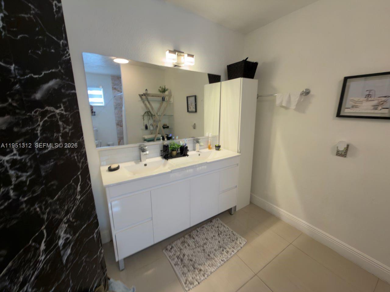 224 East 42nd Street Hialeah, FL 33013 - Photo 35 of 59 a bathroom with a sink a mirror and a shower