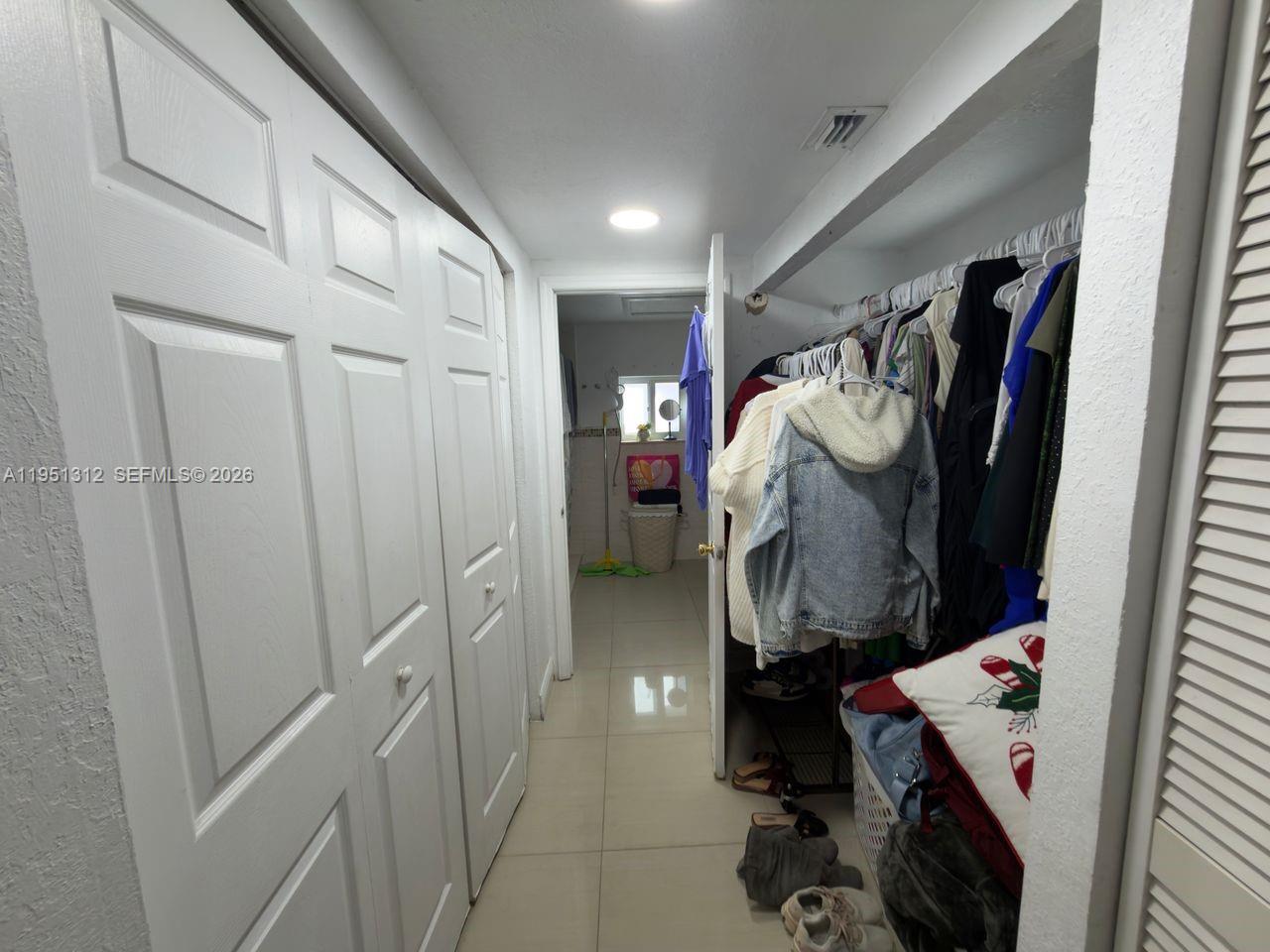 224 East 42nd Street Hialeah, FL 33013 - Photo 44 of 59 a view of walk in closet with clothes and shoes