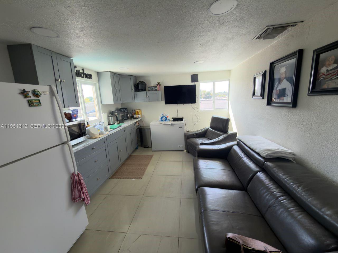 224 East 42nd Street Hialeah, FL 33013 - Photo 45 of 59 a living room with furniture and a flat screen tv