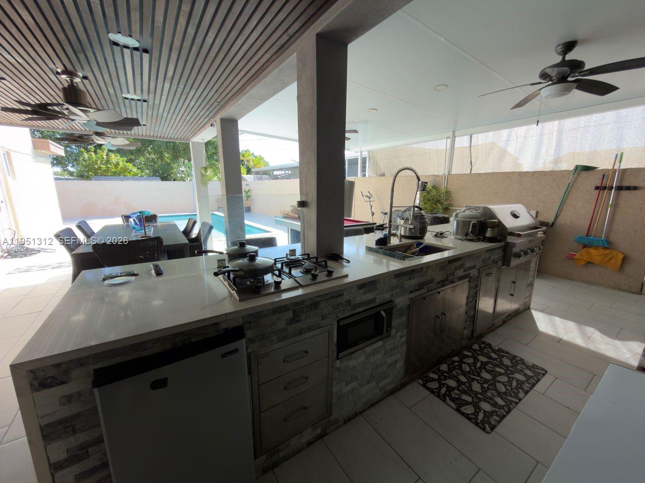 224 East 42nd Street Hialeah, FL 33013 - Photo 52 of 59 a kitchen with stainless steel appliances kitchen island granite countertop a sink stove and large window