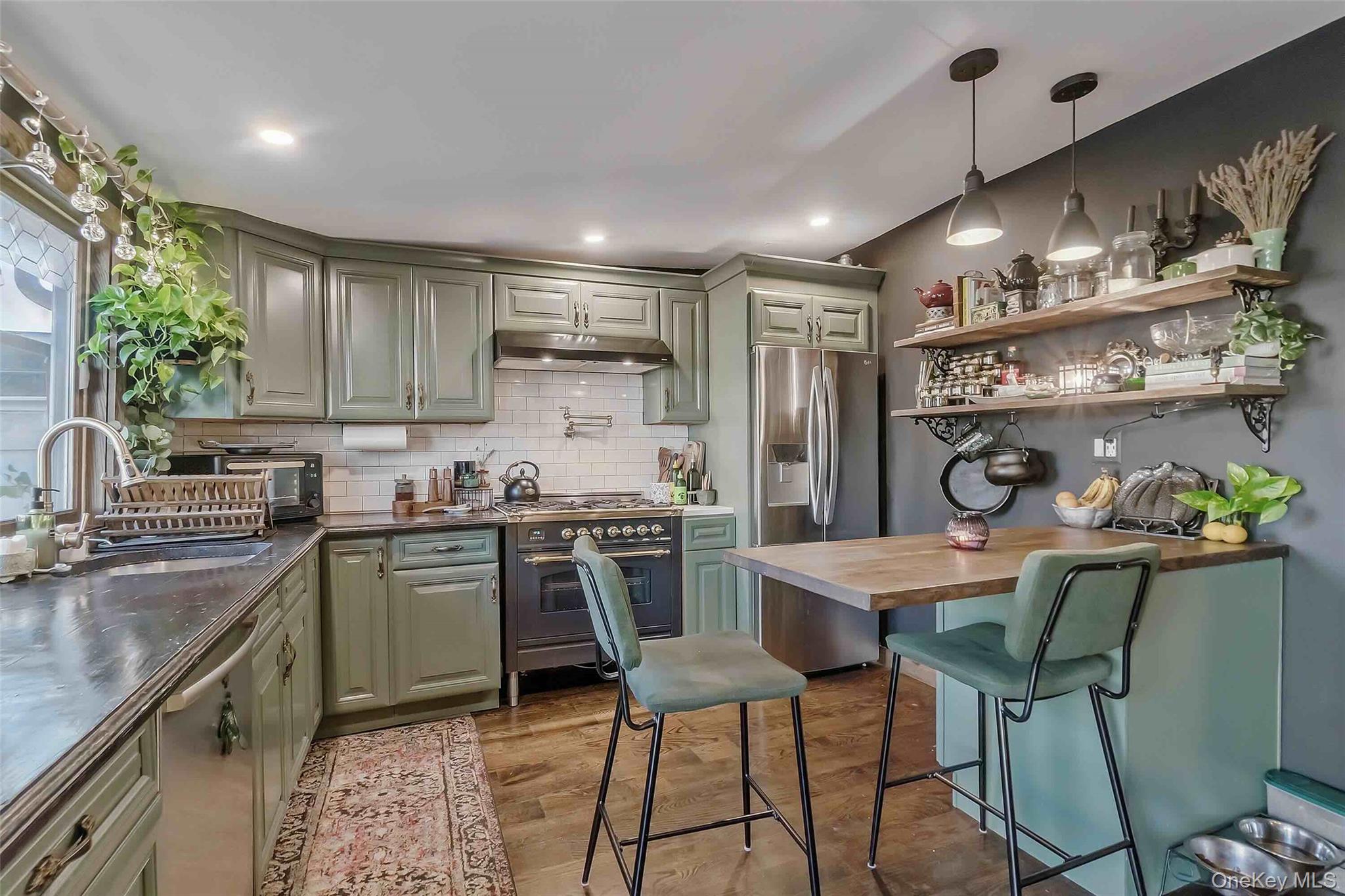 27 West 11th Road Queens, NY 11693 - Photo 11 of 18 Kitchen with open shelves, stainless steel appliances, green cabinets, light wood-style flooring, and pendant lighting