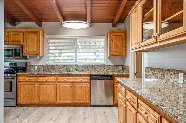 a kitchen with granite countertop a sink and a stove