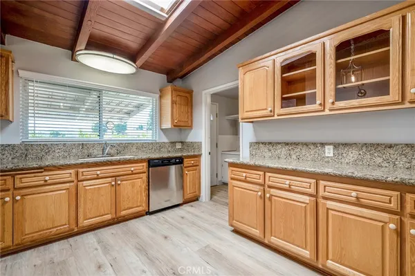 a kitchen with granite countertop cabinets stainless steel appliances a sink and a large window