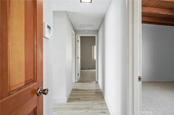 a view of a hallway with wooden floor and staircase