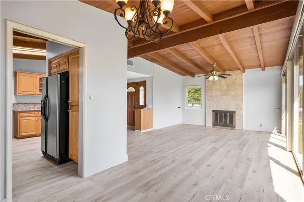 a view of empty room with wooden floor and fireplace