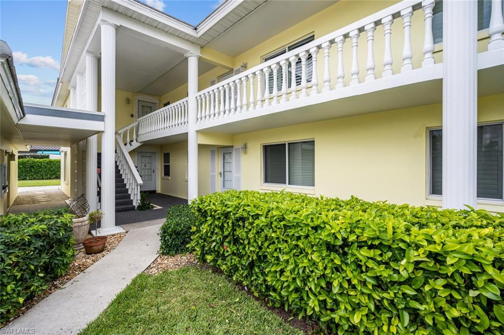 4155 Crayton Road, Unit 201 Naples, FL 34103 - Photo 1 of 24 a view of a house with brick walls and flower plants