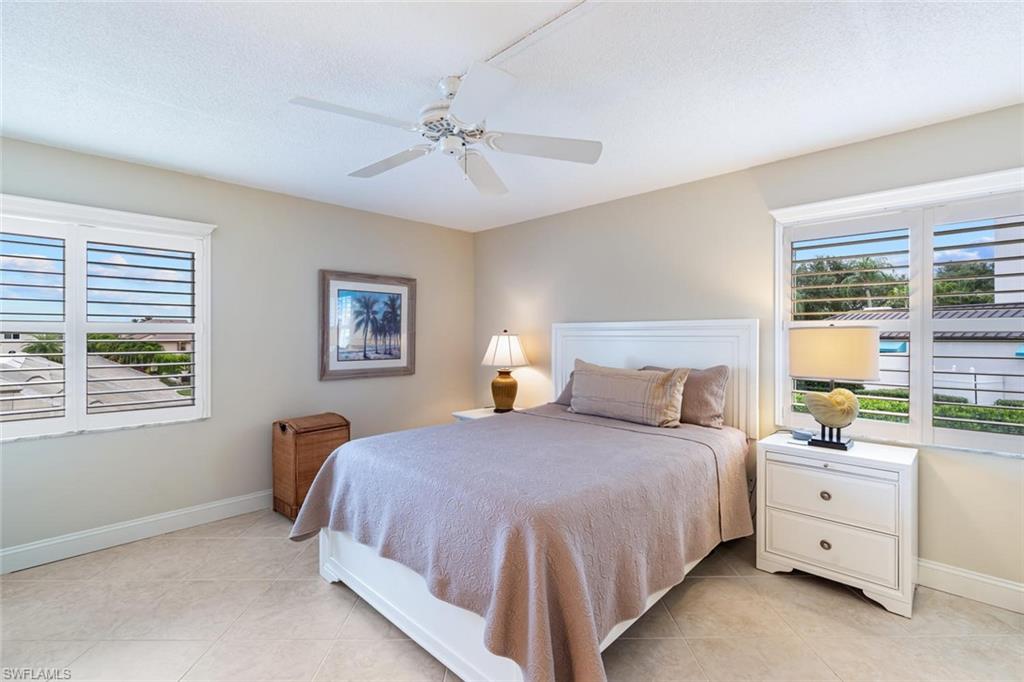 4155 Crayton Road, Unit 201 Naples, FL 34103 - Photo 11 of 24 a bedroom with a bed dresser and a window