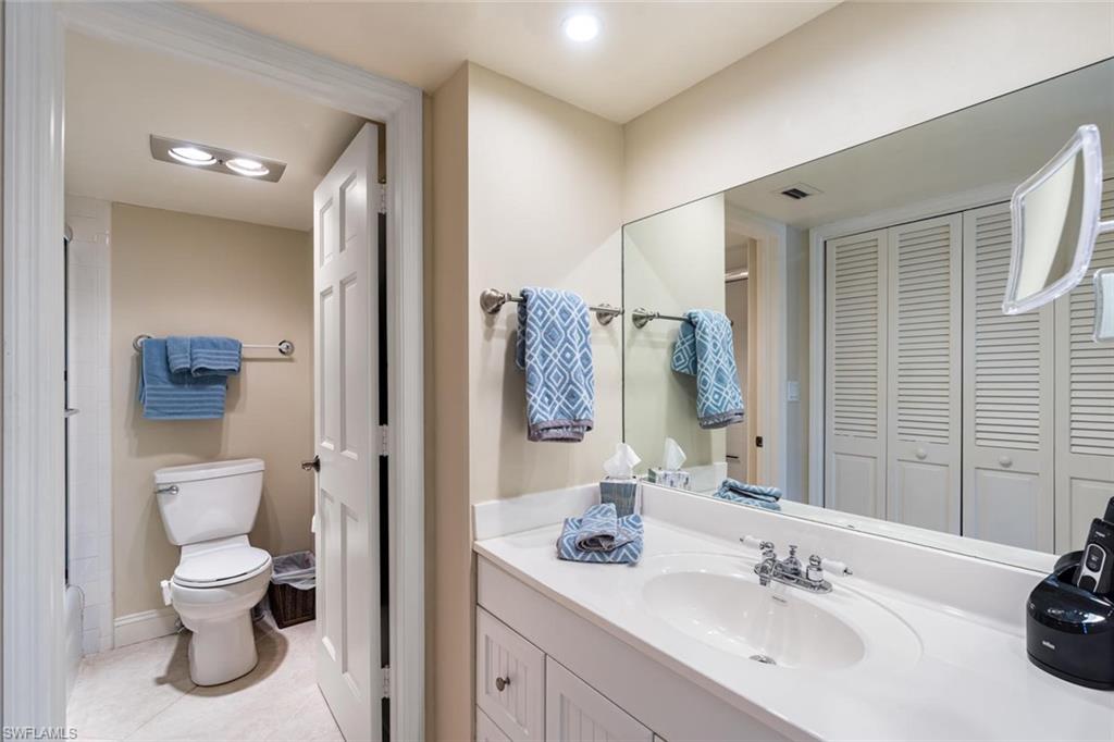 4155 Crayton Road, Unit 201 Naples, FL 34103 - Photo 13 of 24 a bathroom with a toilet sink and mirror