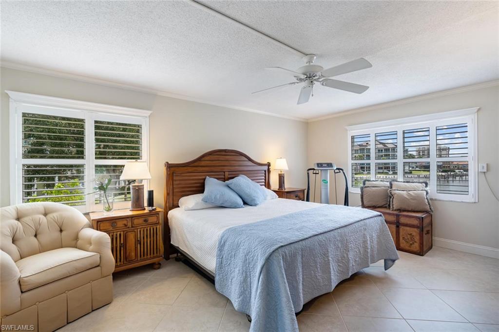 4155 Crayton Road, Unit 201 Naples, FL 34103 - Photo 14 of 24 a bedroom with a bed couch and a large window