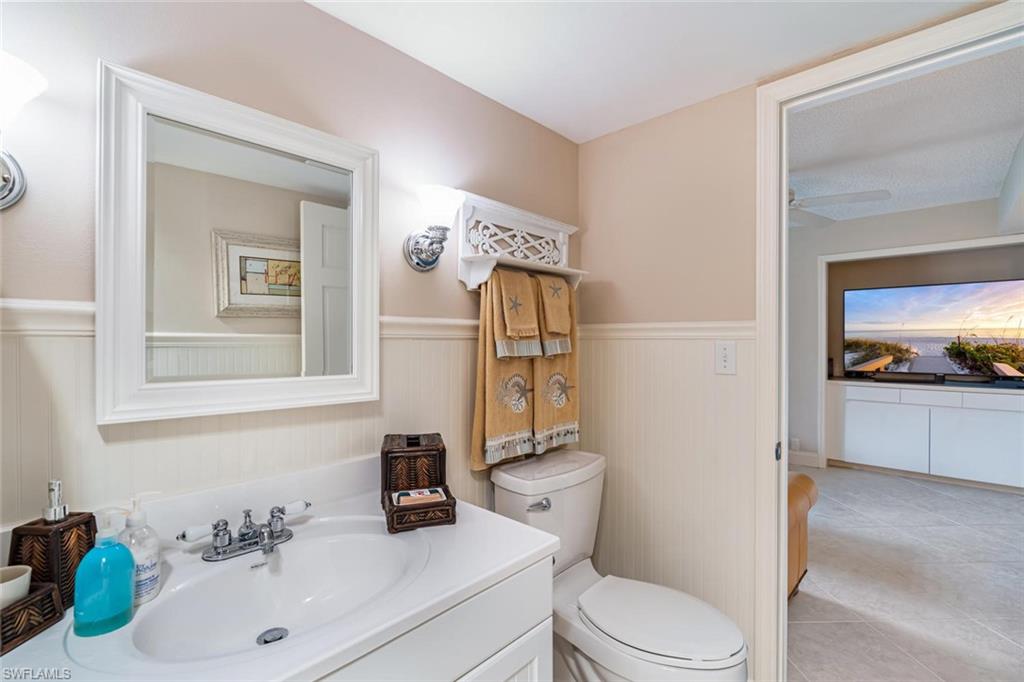 4155 Crayton Road, Unit 201 Naples, FL 34103 - Photo 19 of 24 a bathroom with a sink vanity mirror and toilet