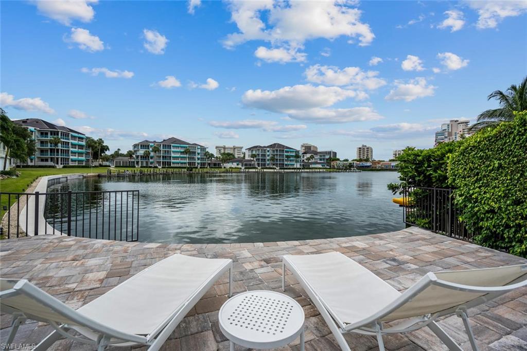 4155 Crayton Road, Unit 201 Naples, FL 34103 - Photo 22 of 24 a view of a lake with a patio