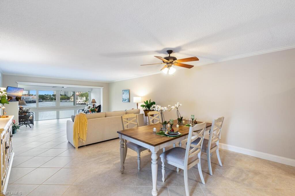 4155 Crayton Road, Unit 201 Naples, FL 34103 - Photo 5 of 24 a dining room with furniture and chandelier