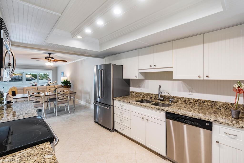 4155 Crayton Road, Unit 201 Naples, FL 34103 - Photo 7 of 24 a kitchen with stainless steel appliances granite countertop a sink stove and refrigerator