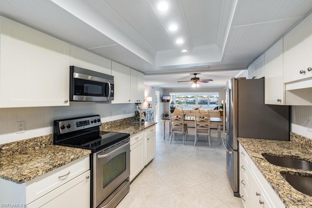 4155 Crayton Road, Unit 201 Naples, FL 34103 - Photo 8 of 24 a kitchen with stainless steel appliances granite countertop a stove refrigerator and a sink