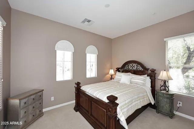 a bedroom with a bed and a dresser next to a window