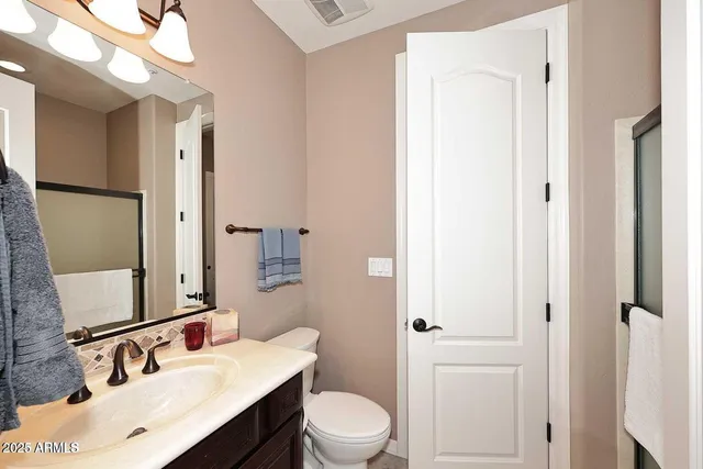 a bathroom with a sink vanity mirror and toilet