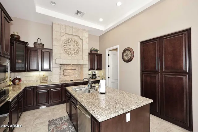 a kitchen with stainless steel appliances granite countertop a sink refrigerator and cabinets