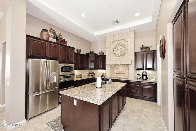 a kitchen with granite countertop a refrigerator stove and sink