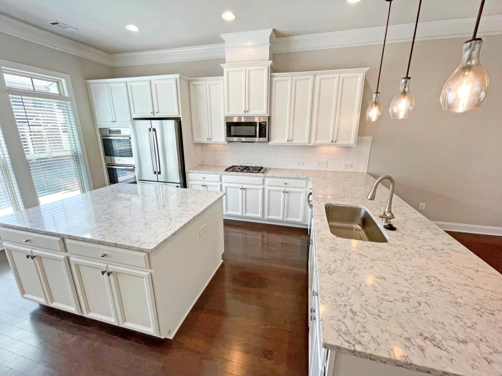 4129 Townsend Lane Dunwoody, GA 30346 - Photo 9 of 38 a kitchen with stainless steel appliances granite countertop a sink a stove a refrigerator a center island with wooden floor and cabinets