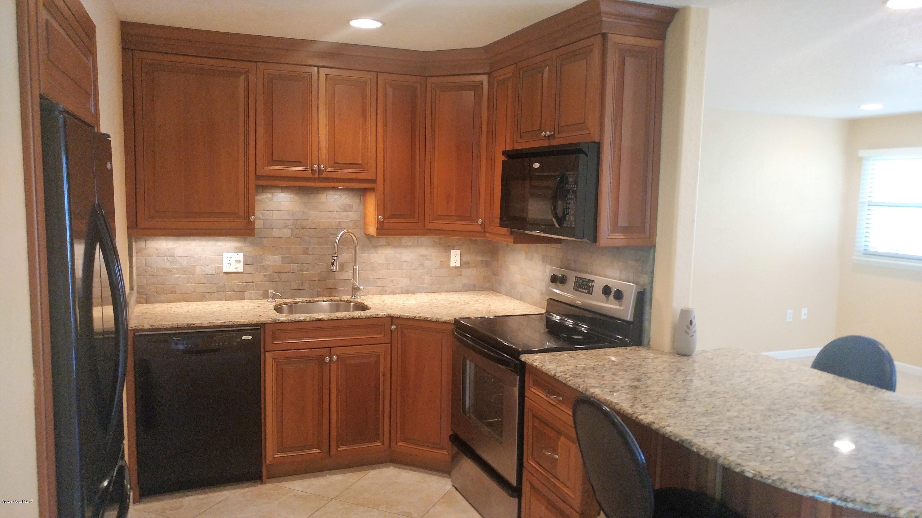 2857 Tropic Road Melbourne, FL 32935 - Photo 13 of 28 a kitchen with a sink stove and cabinets