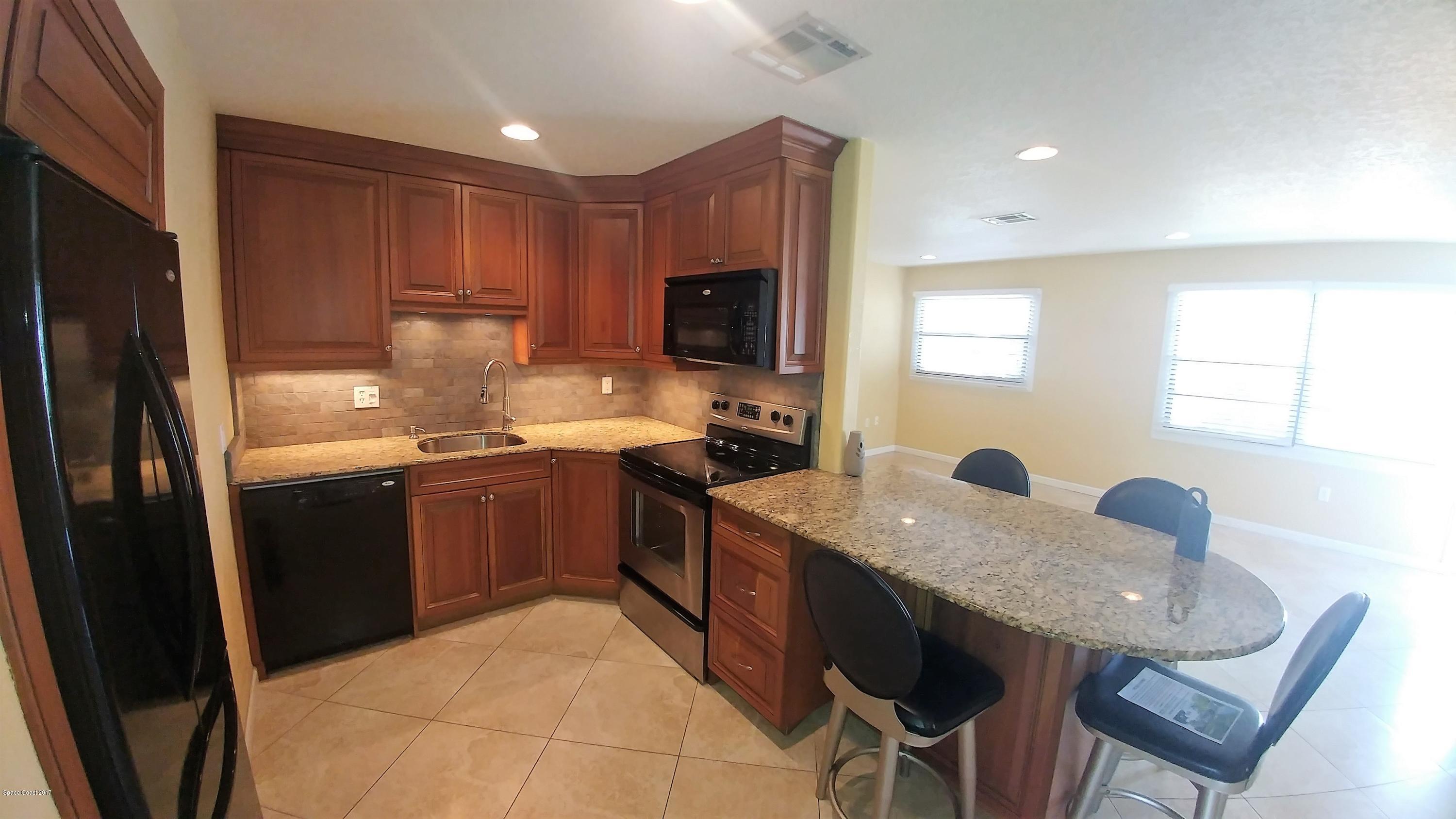 2857 Tropic Road Melbourne, FL 32935 - Photo 17 of 28 a kitchen with granite countertop lots of counter top space and stainless steel appliances