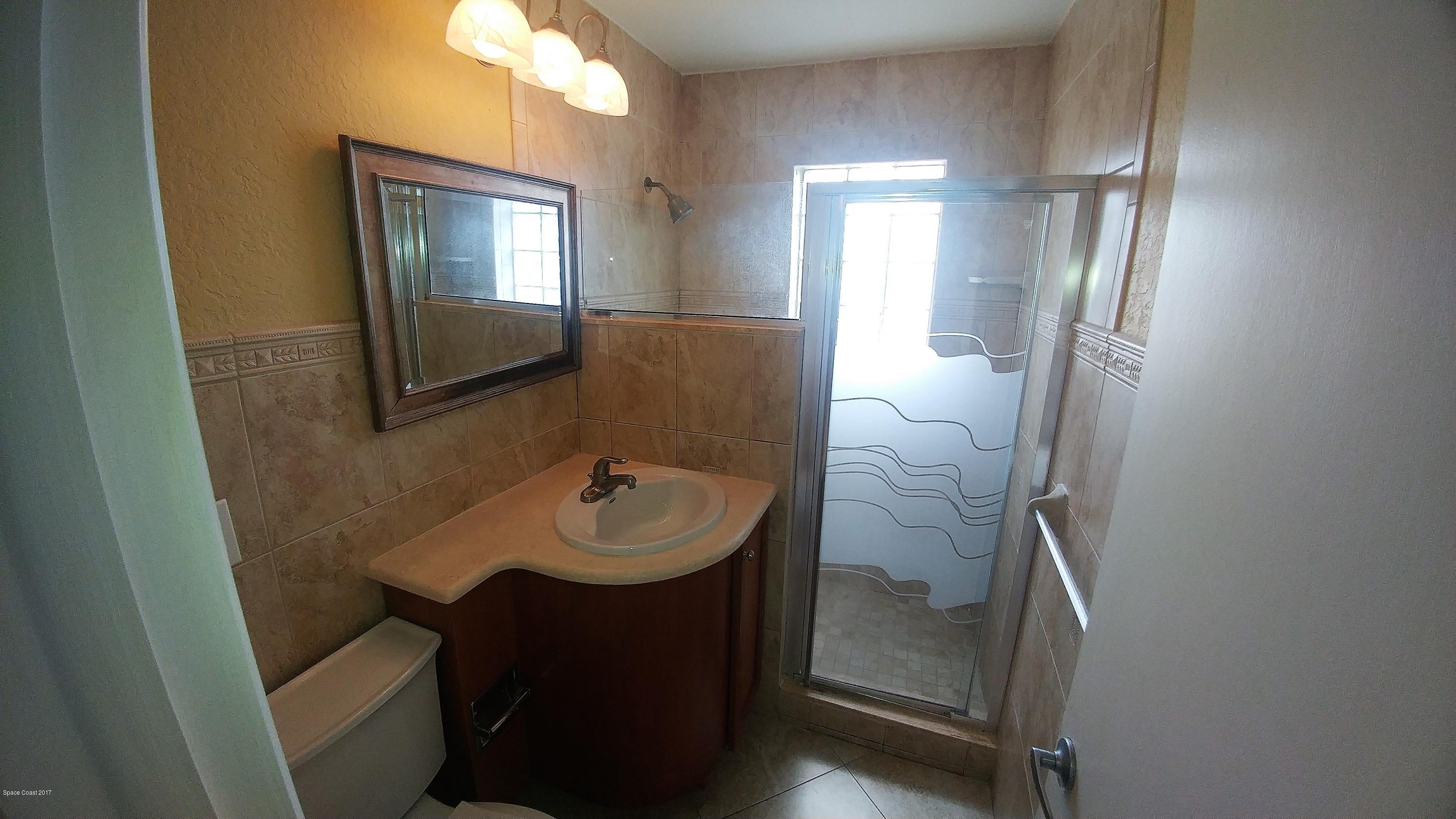 2857 Tropic Road Melbourne, FL 32935 - Photo 22 of 28 a bathroom with a sink a mirror and vanity