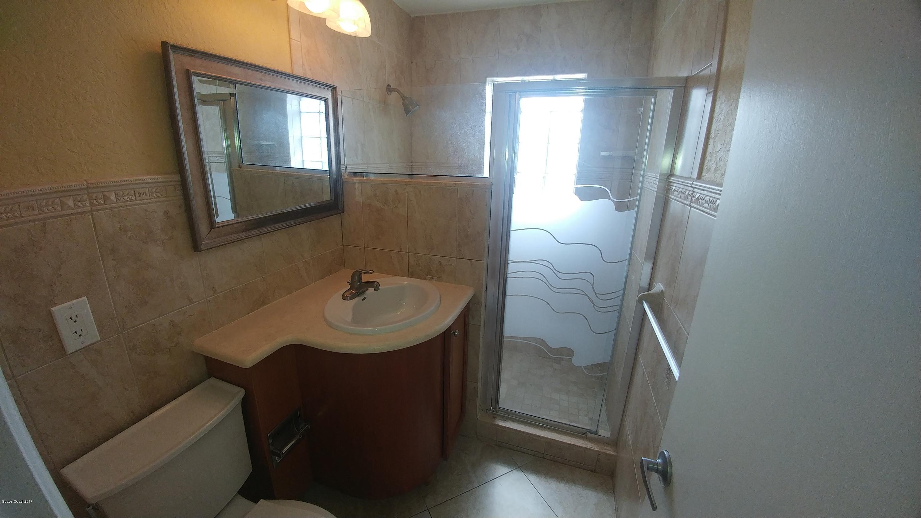 2857 Tropic Road Melbourne, FL 32935 - Photo 24 of 28 a bathroom with a sink a toilet and mirror