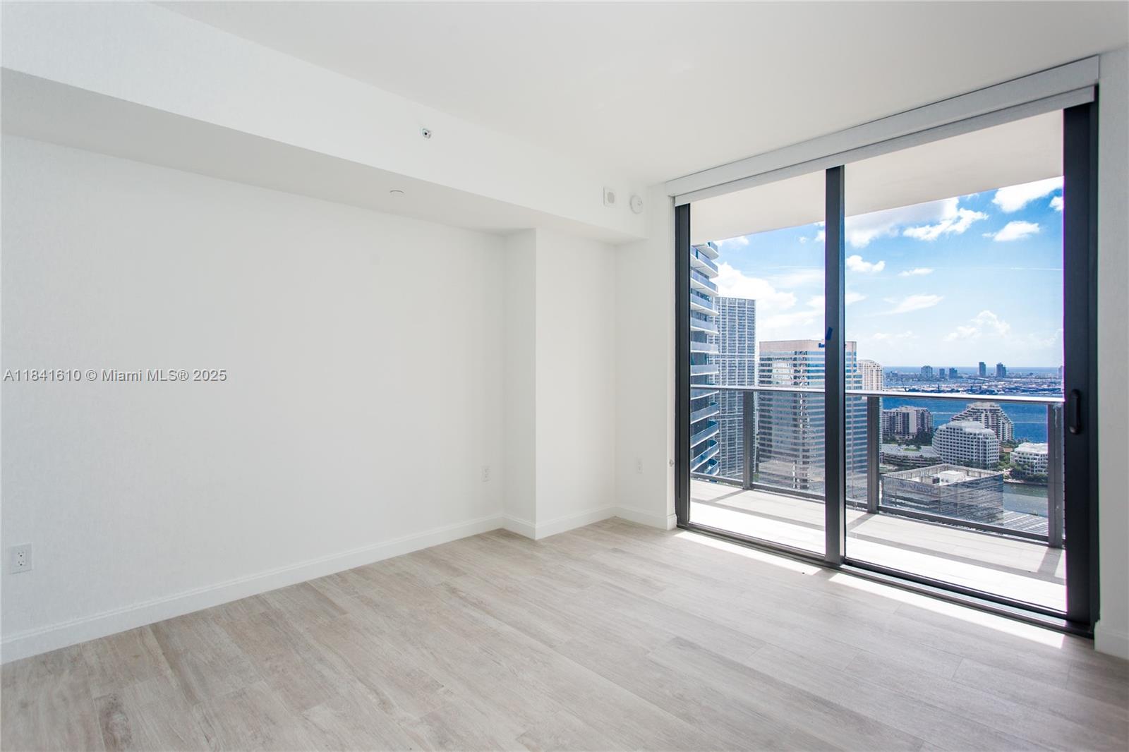 45 Southwest 9th Street, Unit 3803 Miami, FL 33130 - Photo 8 of 54 a view of an empty room with wooden floor and a window
