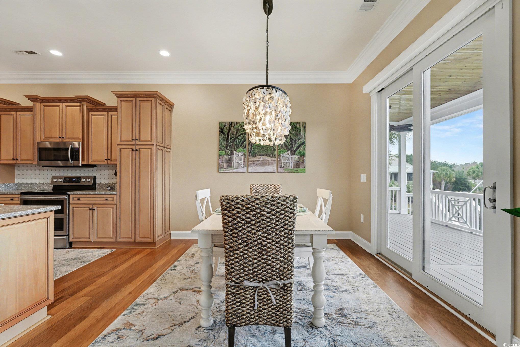 1710 Pond Road Murrells Inlet, SC 29576 - Photo 12 of 39 Dining area with a chandelier, crown molding, and light Brazilian cherry wood finished floors