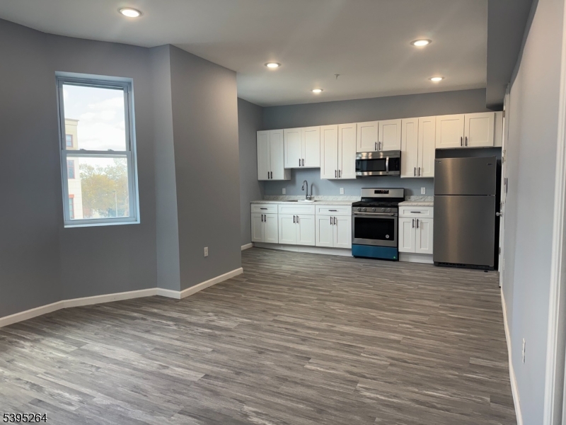 a kitchen with stainless steel appliances granite countertop a refrigerator sink and stove