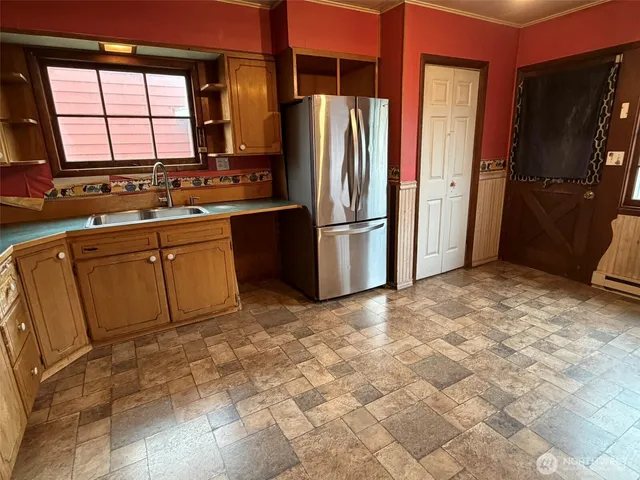 a kitchen with stainless steel appliances a refrigerator sink and cabinets