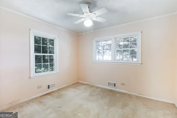 an empty room with a window and a fan