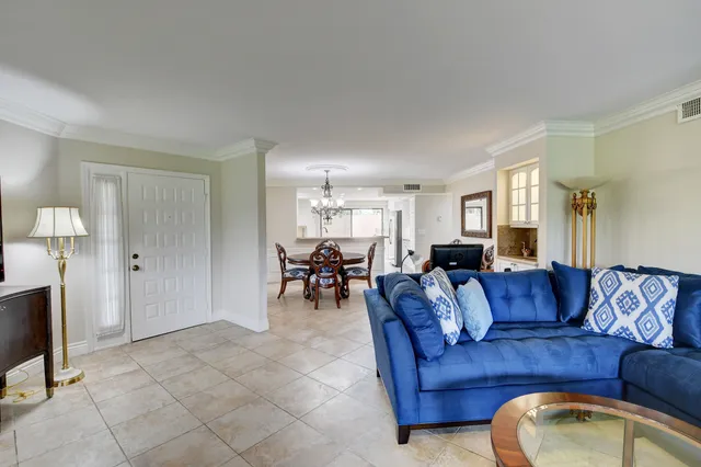 a living room with furniture and a dining table with kitchen view