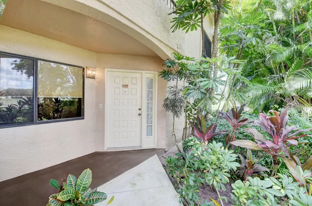 an aerial view of a house with a garden and lake view